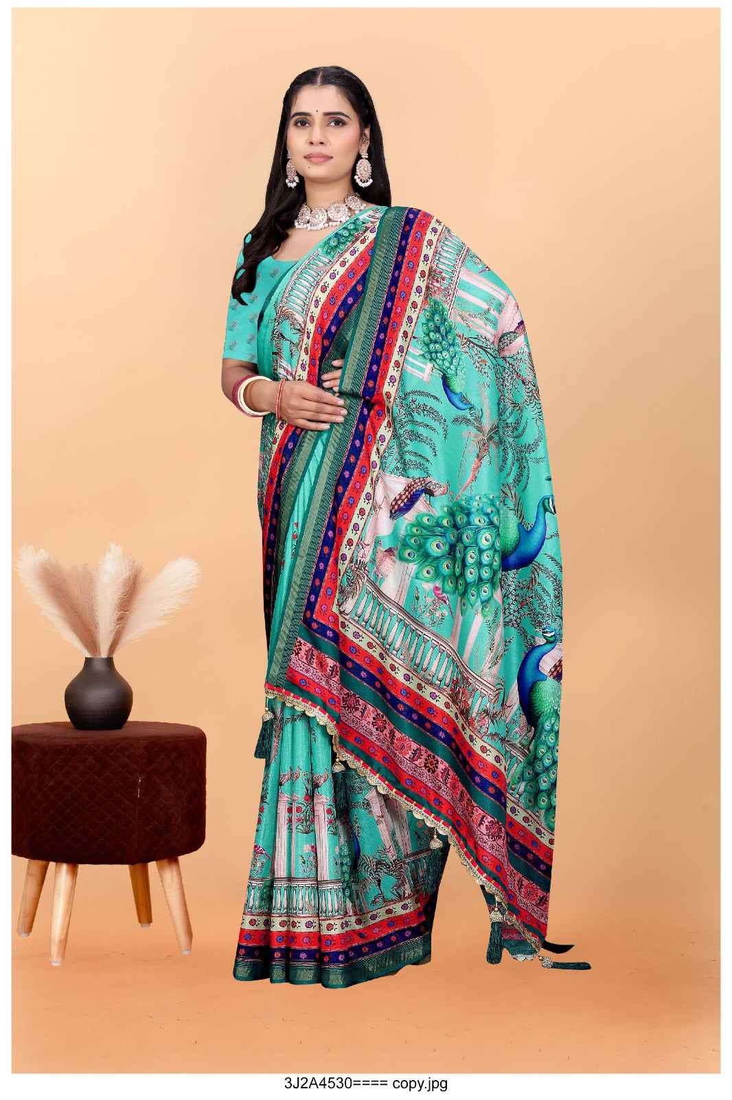 turquoise saree with vibrant peacock motifs and a detailed border