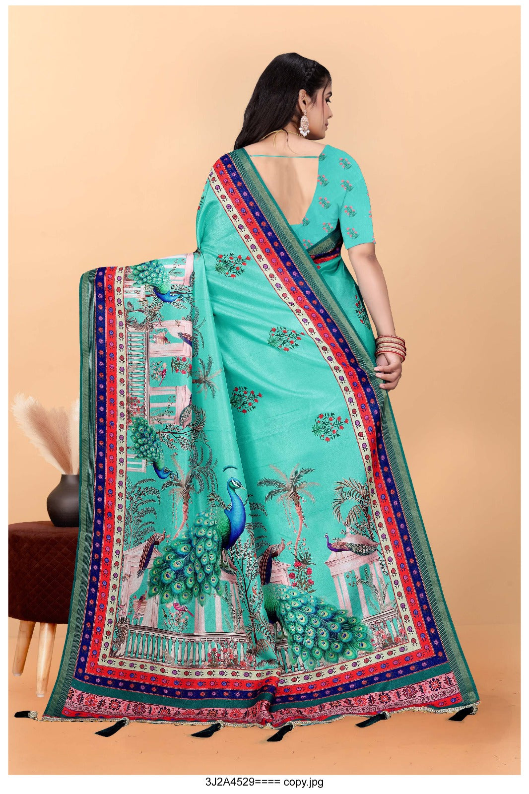 turquoise saree with vibrant peacock motifs and a detailed border