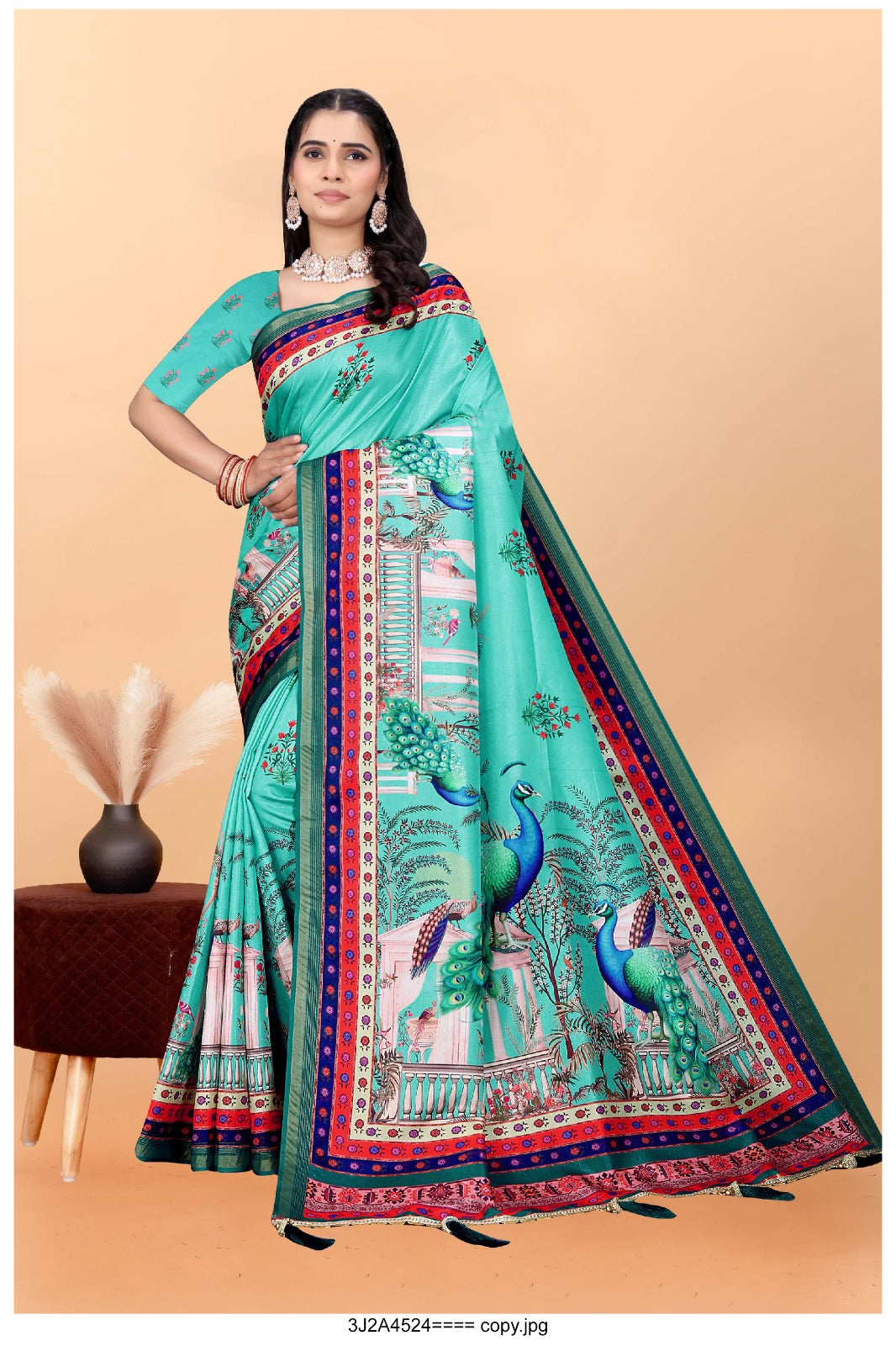 turquoise saree with vibrant peacock motifs and a detailed border