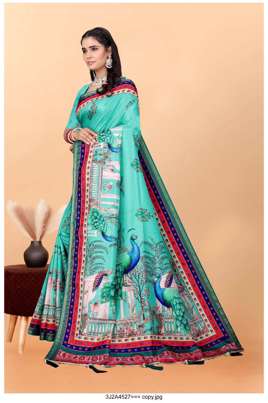 turquoise saree with vibrant peacock motifs and a detailed border